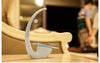 Moderne LED-Schreibtischlampe mit kabelloser Ladestation für Smartphones und platzsparendem Design.