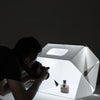Fotograf nutzt LED Fotobox für professionelle Produktfotos mit heller Beleuchtung und gleichmäßigen Lichtverhältnissen