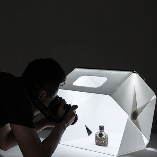 Fotograf nutzt LED Fotobox für professionelle Produktfotos mit heller Beleuchtung und gleichmäßigen Lichtverhältnissen