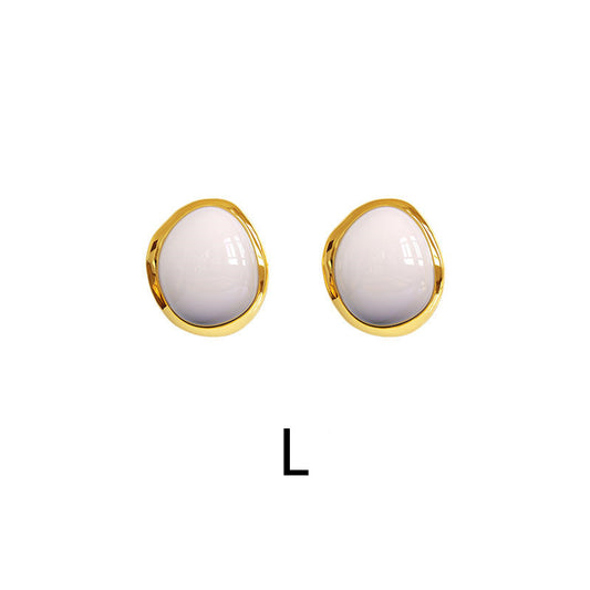 Minimalistische Goldohrringe mit milchig weißen Steinen im eleganten und modernen Schmuckdesign